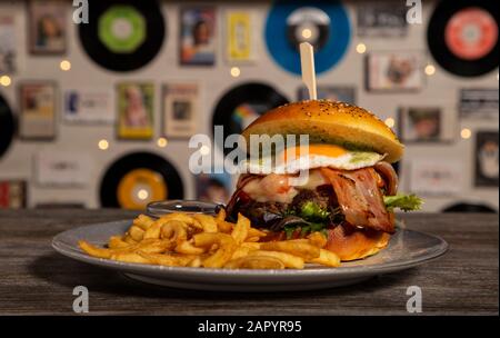 Hausgemachter Kalbsburger mit Speck, Käse und frittiertem Ei mit Pommes. Isoliertes Bild Stockfoto