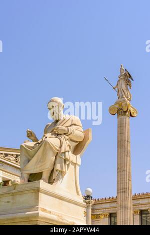 Platon-Skulptur, die von einer Athena-Statue übersehen wird, auf einer der Säulen auf beiden Seiten der Akademie von Athen, Athen, Griechenland Stockfoto