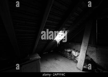 Im Dachgeschoss eines alten Hauses mit Kopfsteinpflaster. Schwarz-weiß. Stockfoto