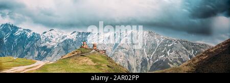 Stephantsminda, Georgia. Gergeti Trinity Church Oder Tsminda Sameba - Holy Trinity Church Near Village Of Gergeti In Georgia. Panoramaaussicht Bei Spring S Stockfoto