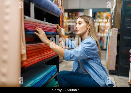 Verkäuferin Maßnahmen Stoff in Textil store Stockfoto