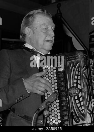 Akkordeonist Johnny Meijer 75 jaar, krijgt Gouden Speld gemeente Amsterdam van burgemeester Van Thijn; Johnny Meyer spelend op accordeon 1. Oktober 1987; ' Stockfoto