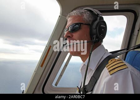 Pilot eines 3B-NZF Bell 206B JetRanger III Touristenhubschraubers im Flug, Mauritius. Stockfoto