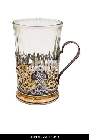 Facettiertes Glas in einem alten weißen Metall-Cup-Halter. Nahaufnahme. Auf weißem Hintergrund isolieren Stockfoto