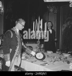 Königin Juliana und Prinz Bernhard geben ein Neujahrsessen im Huis ten Bosch Palast, Den Haag Einer der Lakaien zeigt eines der neuen Zeichen für das Corps [Text gebrochen] Datum: 15. Januar 1964 Ort: Den Haag, Zuid-Holland Schlüsselwörter: Zeichen, Kerzen, Lakaien Stockfoto
