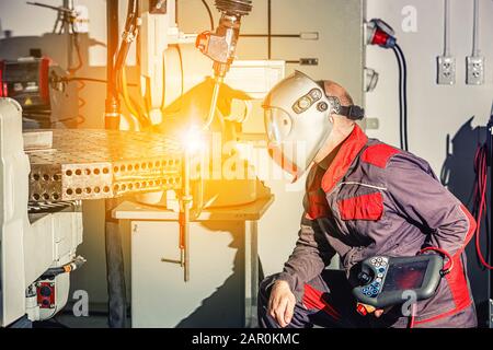 Ingenieure verwenden die Fernsteuerung des Roboterschweißens in einer intelligenten Fabrik, Industrie 4.0 im Werk des Herstellers von Produktionslinien Stockfoto