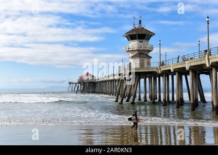 HUNTINGTON BEACH, KALIFORNIEN - 22. JANUAR 2020: Ein Surfer und sein Brett am Huntington Beach Pier. Stockfoto