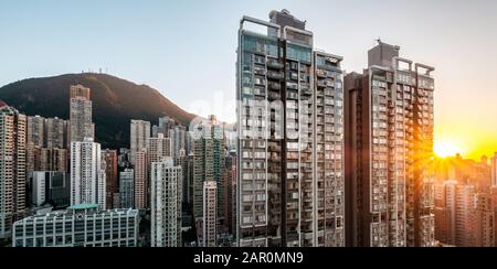 Sonnenhimmel über der modernen Skyline der Stadt mit Wohnhäusern in Hongkong - Stockfoto