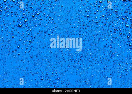 Glitzernde perlen Wassertropfen auf einem blauen Hintergrund in eine zufällige Textur und Muster für ein Hintergrundbild Stockfoto