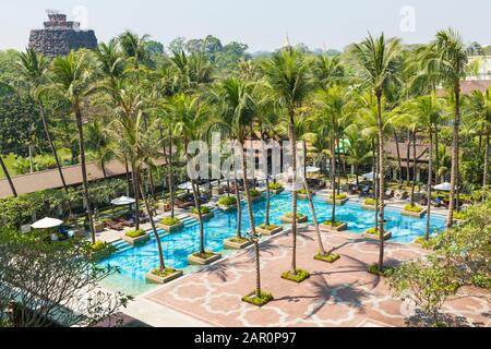 Außenpool, der von Palmen Chatrium Hotel, Royal Lake, Yangon, Myanmar (Birma), Asien im Februar umgeben Stockfoto