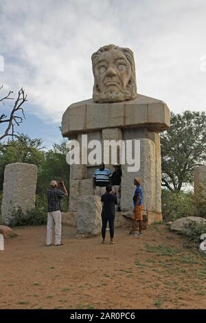 Kopfstatue von Paul Kruger mit Menschen darunter, Eingangstor im Kruger National Park, Mpumalanga, Südafrika. Stockfoto