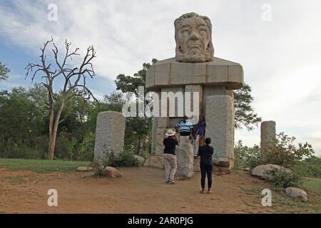 Kopfstatue von Paul Kruger mit Menschen darunter, Eingangstor im Kruger National Park, Mpumalanga, Südafrika. Stockfoto