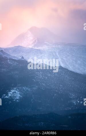 Buntes Morgenlicht trifft an einem verschneiten Wintertag auf den Gipfel des Longs Peak Stockfoto