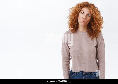 Albern, freudig und verspielt gluckender Rotkopf-Flustiges Mädchen, rot lockige Frisur, faltbare Lippen wie Fisch, knallende Augen, neigbarer Kopf mit Spaß, stehendem Child Stockfoto