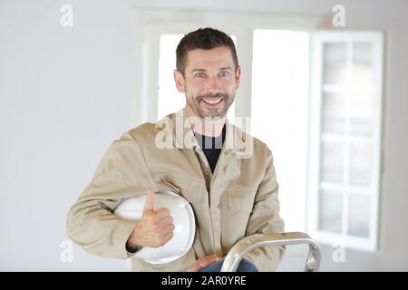 Builder ist auf der Leiter Stockfoto