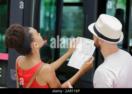 Fröhlicher Tourist, der eine Karte prüft Stockfoto