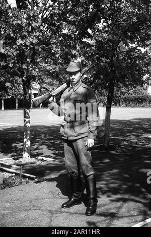 STUPINO, REGION MOSKAU, RUSSLAND - CIRCA 1992: Porträt eines russischen Soldaten der Armee, der mit einer Waffe (Karbin) auf dem Paradeplatz steht. Schwarz und Weiß. Filmscan. Große Körnung. Stockfoto