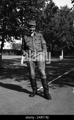 STUPINO, REGION MOSKAU, RUSSLAND - CIRCA 1992: Porträt eines Soldaten der russischen Armee, der auf dem Paradeplatz steht. Schwarz und Weiß. Filmscan. Große Körnung. Stockfoto