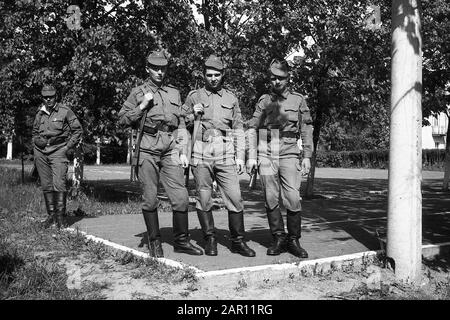 STUPINO, REGION MOSKAU, RUSSLAND - CIRCA 1992: Porträt der Soldaten der russischen Armee, die mit Waffen auf dem Paradeplatz stehen (Karbin). Schwarz und Weiß. Filmscan. Große Körnung. Stockfoto