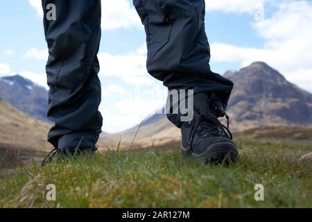 Mann mit leichten Wanderschuhen und wasserdichter Hose im Stehen Glencoe in den schottischen Highlands vereinigtes Königreich Stockfoto