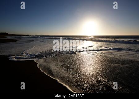 Sonne untergeht über dem sandigen Strand auf dem pazifischen Ozean los Pellines maule chile Südamerika Stockfoto
