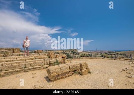 Tourist erkundet Tempelruinen in Agrigent. Das Valle dei Templi von Agrigent auf Sizilien gehört zum UNESCO-Weltkulturerbe. Stockfoto