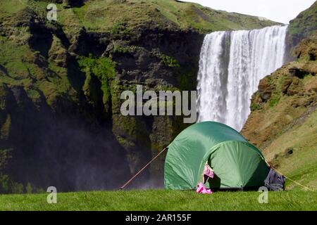 Kleines Zelt für zwei Personen mit Kleidung, die beim Wasserfall Island im Skogafoss zelten Stockfoto