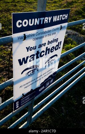 Die Landesuhr der Hampshire Constabulary arbeitet in diesem am Bauerntor angebrachten Schild, um illegale Aktivitäten auf dem Land abzuschrecken Stockfoto