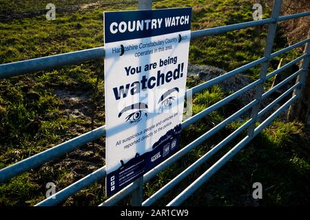 Die Landesuhr der Hampshire Constabulary arbeitet in diesem am Bauerntor angebrachten Schild, um illegale Aktivitäten auf dem Land abzuschrecken Stockfoto