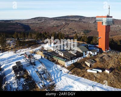 Luftdronblick auf den Wurmberg mit dem Brocken im Hintergrund. Neu errichteter Aussichtsturm auf dem Gipfelplateau. Harz, Deutschland. Stockfoto