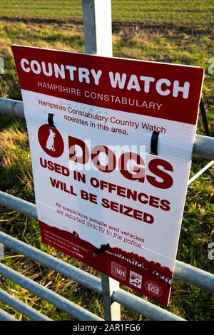 Die Landesuhr der Hampshire Constabulary arbeitet in diesem Bereich mit einem Hundeschild am Tor der Farm, um illegale Aktivitäten auf dem Land zu verhindern Stockfoto