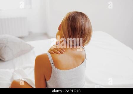 Schönheit, junge Frau mit Kopfschmerzen im Bett Stockfoto