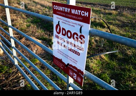 Die Landesuhr der Hampshire Constabulary arbeitet in diesem Bereich mit einem Hundeschild am Tor der Farm, um illegale Aktivitäten auf dem Land zu verhindern Stockfoto