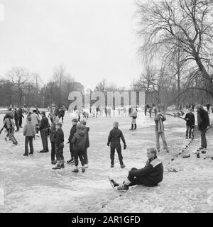 Winterszenen in Amsterdam Menschen beim Schlittschuhlaufen im Vondelpark Datum: 21. november 1965 Ort: Amsterdam, Noord-Holland Schlagwörter: Eis, Parks, Schlittschuhlaufen, Winter Stockfoto