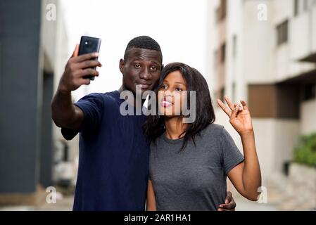 Tourismus und Menschen Konzept - lächelnde Paare von Reisenden, die Fotos auf dem Handy in der Stadt machen Stockfoto