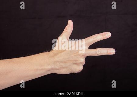 Hand zählt drei, drei Finger ausgestreckt, Schild für drei Stockfoto