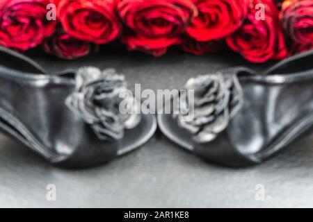 Schuhe mit hohem Absatz, Rosen auf schwarzem Steingrund Stockfoto