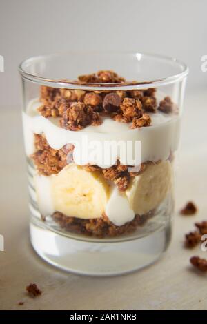 Food-Fotografie eines Bananenparfait mit Schokoladengranola. Stockfoto