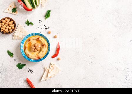 Traditioneller Vorspeise Hummus aus dem Nahen Osten mit frischem Pita Brot, Kichererbsen und Gemüse, gewürzt mit nativem Olivenöl und Paprika, Stockfoto