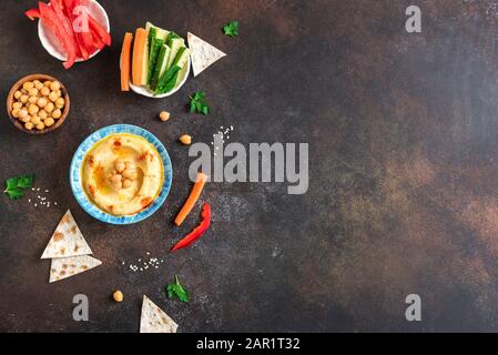 Traditioneller Vorspeise Hummus aus dem Nahen Osten mit frischem Pita Brot, Kichererbsen und Gemüse, gewürzt mit nativem Olivenöl und Paprika, Stockfoto