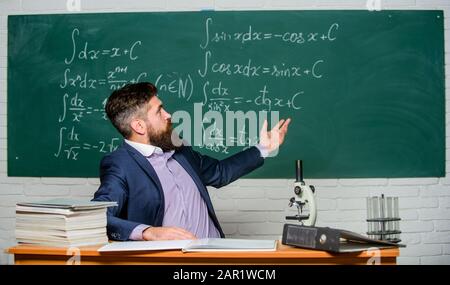 Lehre und Bildung. Universitätslehrer verwenden Lehrmittel. Bärtiger Mann unterrichtet Chemie in der Schule. Pädagogische Techniken und Unterrichtsmethoden. Stockfoto