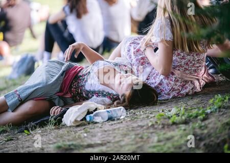 München, DEUTSCHLAND - 29. September 2019: Junge attraktive Frau im traditionellen bayerischen Dirndl liegt auf Gras, das im Oktober in münchen zu viel Alkohol übergegangen ist Stockfoto