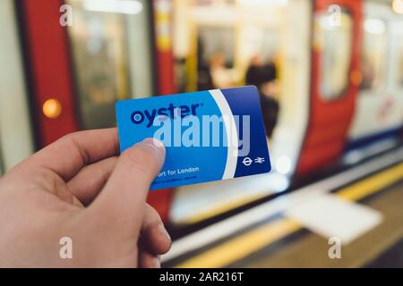 London, GROSSBRITANNIEN - 11. November 2019: Männliche Hand hält London Oyster Card in der U-Bahn des öffentlichen Verkehrs. Die Austernkarte wird für die Verwendung von englisch verwendet Stockfoto