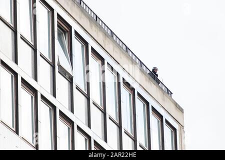 Leeds, GROSSBRITANNIEN - 05. Mai 2019: Bewaffneter Polizist stand auf einem Dach im stadtzentrum von leeds und blickt auf die Menge von Tour de yorkshire Stockfoto