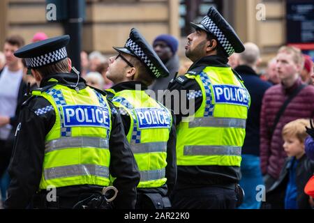 Leeds, GROSSBRITANNIEN - 05. Mai 2019: 3 Polizisten in gelben Westen, die die große Leinwand bei der Tour de yorkshire Veranstaltung in der innenstadt von leeds beobachten Stockfoto