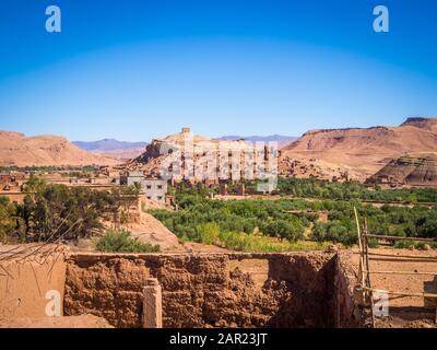 Ksar von Ait-Ben-Haddou umgeben von Hügeln und Grün unter einem Blauer Himmel in Marokko Stockfoto