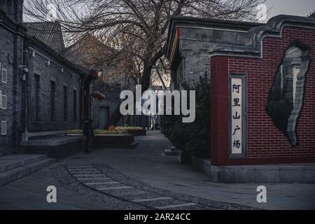 Peking, China - 29. Dezember 2018: Eine Frau, die chinesische Schriftzeichen auf dem Dach eines Gebäudes betrachtet, das von der traditionellen Atmosphäre Pekings umgeben ist Stockfoto