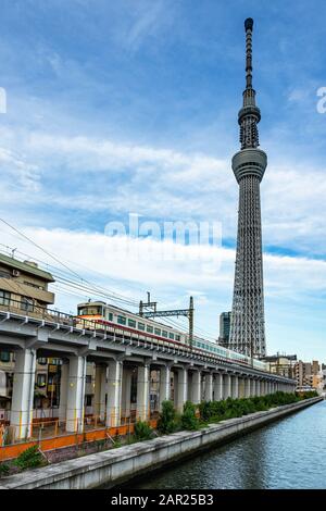 Vertikale Aufnahme des berühmten Tokyo Skytree Turms mit einem Trainiere im Vordergrund Stockfoto