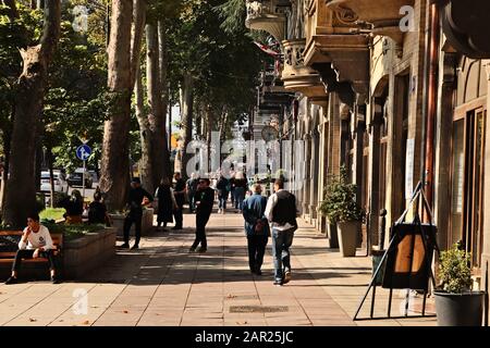 Tiflis, GEORGIEN - 24. September 2019: Menschen, die die Straße Rustaveli Avenue in Tiflis, Georgien, hinunter laufen. Dies ist eine beliebte Touristenattraktion in der Stadt. Stockfoto