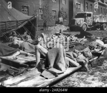 Ungarische Juden, die auf dem Cots außerhalb des Gebäudes liegen, nachdem sie aus den Nazi-Konzentrationslagern in Einrichtungen der US-Armee 121st Evacuation Hosp., Österreich, Foto des U.S. Army Signal Corps, Mai 1945, entfernt wurden Stockfoto